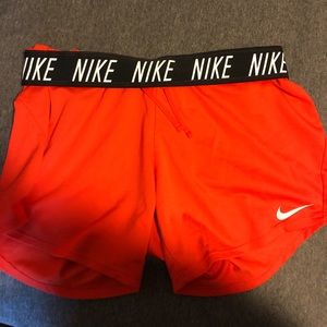 Nike Red-orange Dri-Fit running shorts.